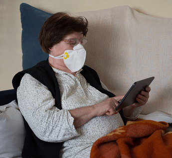 Managing the next COVID Variant - Person in mask looking at tablet